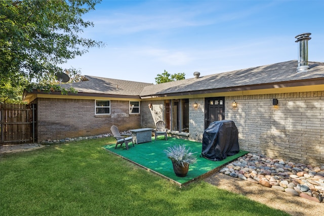 rear view of property featuring a lawn