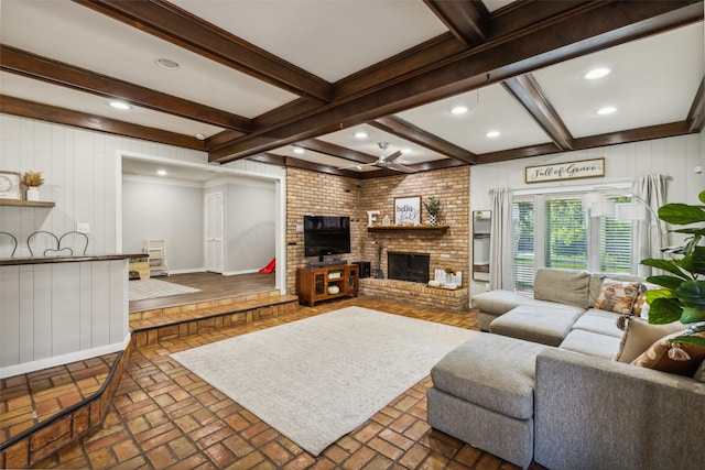 living room featuring a brick fireplace, ceiling fan, crown molding, beamed ceiling, and wood walls