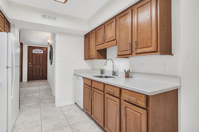 kitchen featuring light tile patterned flooring, sink, and white appliances