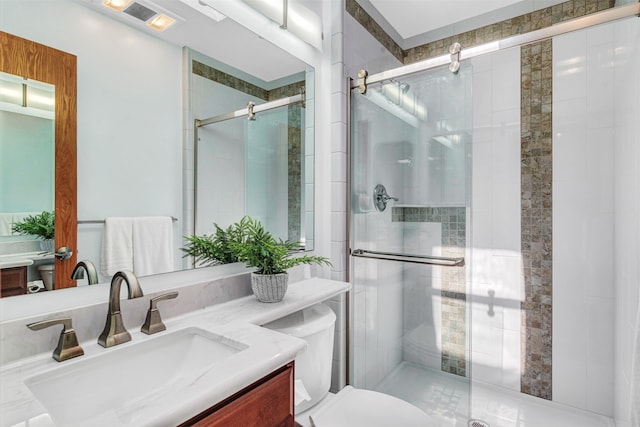 bathroom featuring vanity, toilet, and an enclosed shower