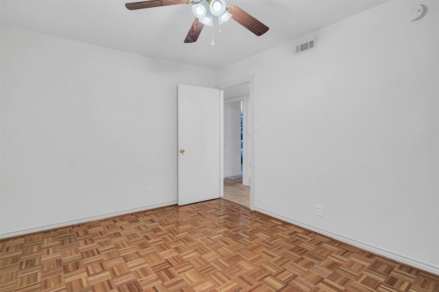 empty room with ceiling fan and light parquet flooring