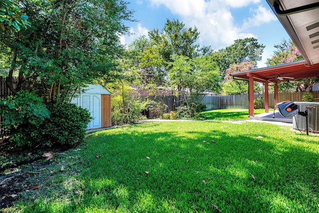 view of yard with a storage shed, a patio area, and central air condition unit