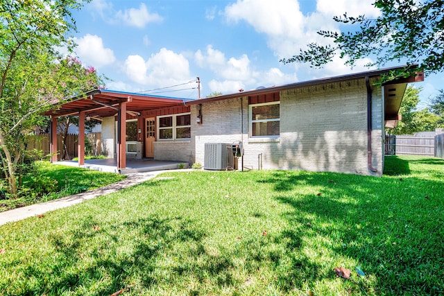 rear view of house with a patio, a yard, a pergola, and central AC unit