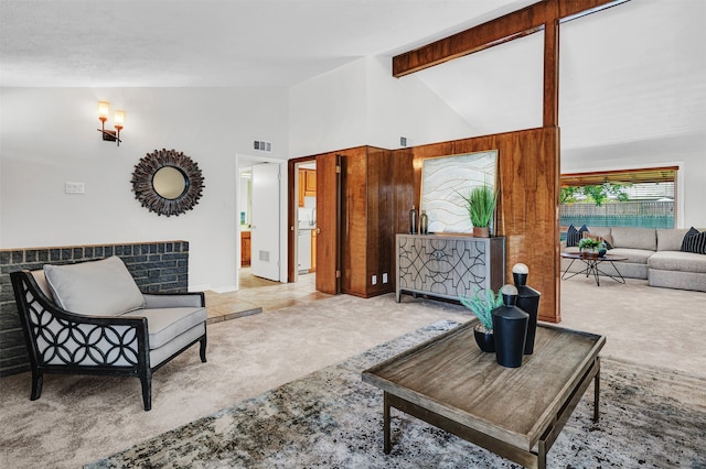 carpeted living room with high vaulted ceiling and beamed ceiling