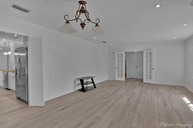 spare room with french doors, light hardwood / wood-style floors, a notable chandelier, and ornamental molding