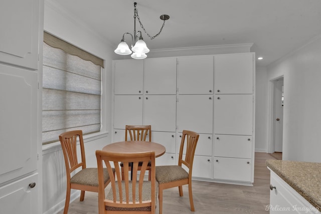 dining area featuring crown molding, an inviting chandelier, and light wood-type flooring