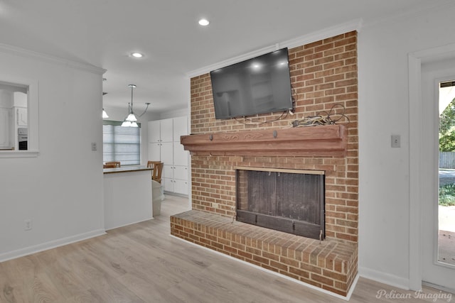 unfurnished living room featuring light hardwood / wood-style floors, ornamental molding, and a brick fireplace