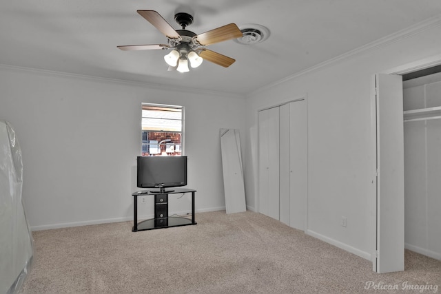 unfurnished bedroom with crown molding, multiple closets, light colored carpet, and ceiling fan