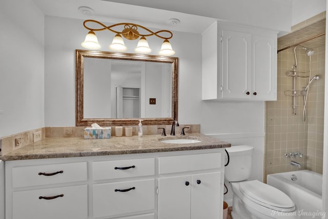 full bathroom featuring toilet, tiled shower / bath combo, and vanity