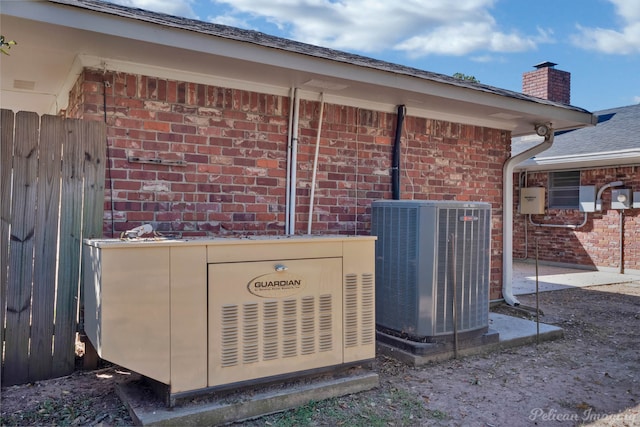 exterior details featuring central AC unit and a wood stove