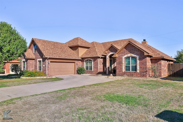 view of front of home with a garage and a front lawn