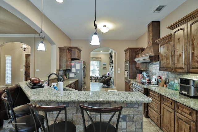 kitchen with appliances with stainless steel finishes, sink, light stone counters, and a breakfast bar