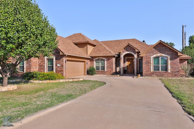 view of front of house with a front yard and a garage