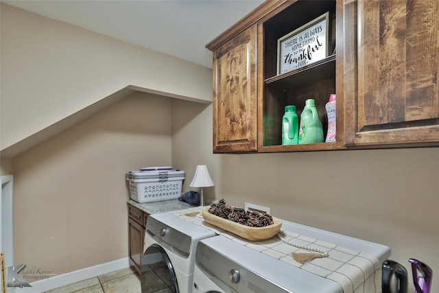 clothes washing area featuring cabinets, washing machine and clothes dryer, and light tile patterned flooring