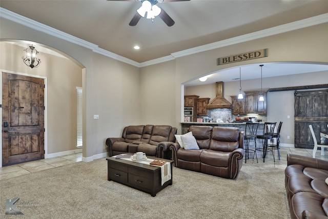 living room featuring ceiling fan with notable chandelier, light colored carpet, and ornamental molding