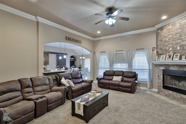 living room with ceiling fan with notable chandelier, crown molding, and light colored carpet