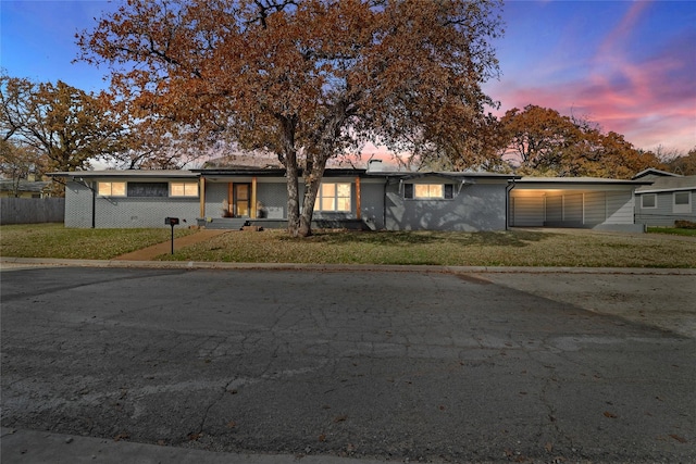 ranch-style home with a lawn