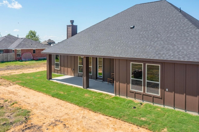 back of property with a lawn and a patio area