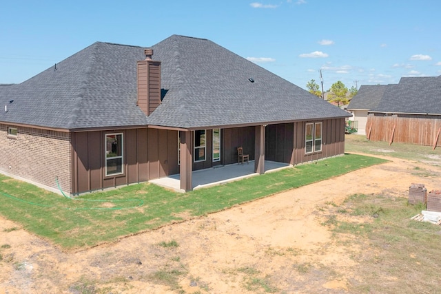 rear view of property featuring a patio and a lawn