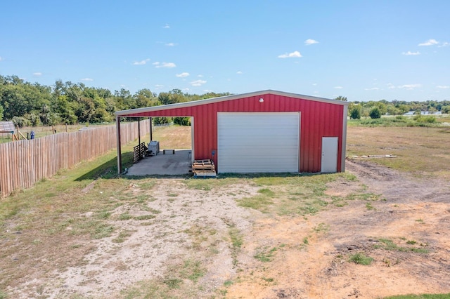 view of outdoor structure with a rural view and a garage