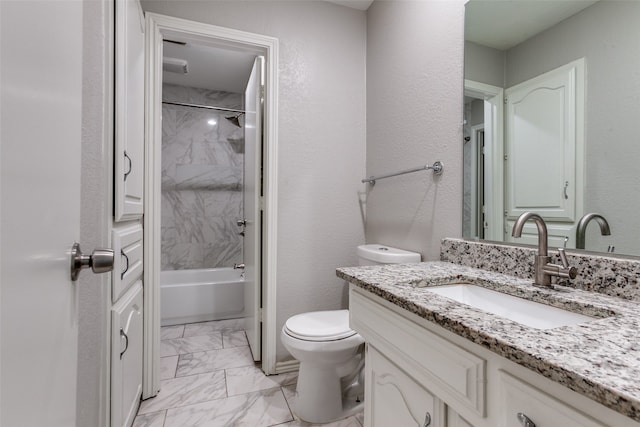 full bathroom featuring tiled shower / bath, vanity, and toilet