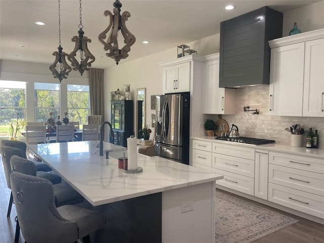 kitchen with white cabinets, a kitchen island with sink, and appliances with stainless steel finishes