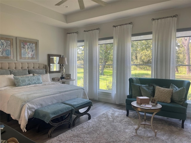 bedroom featuring hardwood / wood-style flooring, multiple windows, and ceiling fan