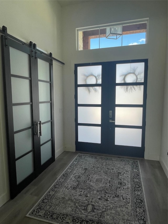 entrance foyer with dark wood-type flooring, a wealth of natural light, and french doors