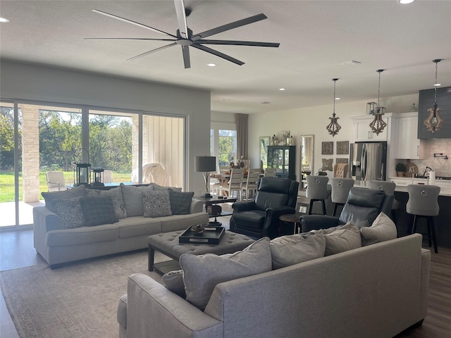 living room with ceiling fan, hardwood / wood-style floors, and a healthy amount of sunlight