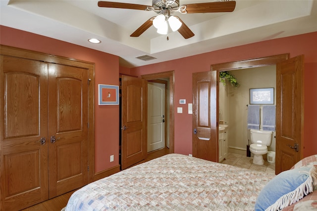 tiled bedroom featuring connected bathroom and ceiling fan