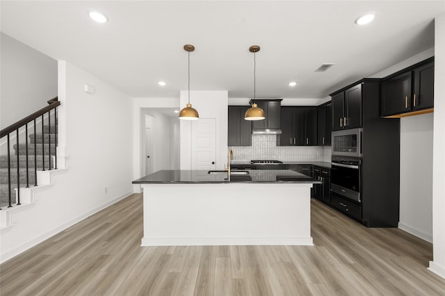 7513 Wild Mint Trl, Midlothian, TX 76084 - kitchen featuring appliances with stainless steel finishes, dark countertops, a sink, tasteful backsplash, and light wood-type flooring