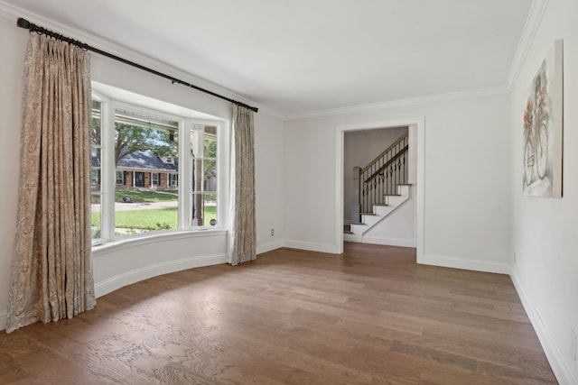 spare room with hardwood / wood-style floors and crown molding