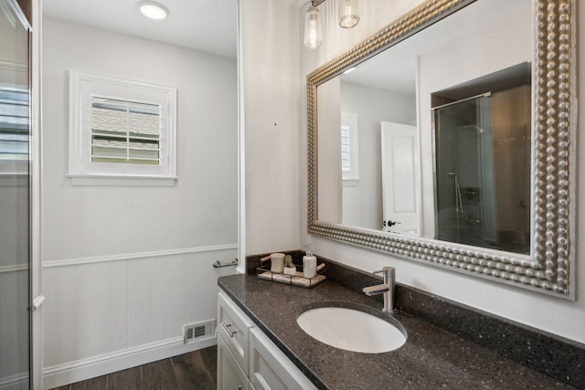 bathroom featuring hardwood / wood-style floors, vanity, and an enclosed shower