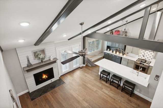 living room with beamed ceiling, hardwood / wood-style floors, and ceiling fan