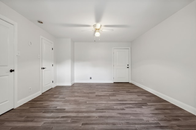 unfurnished room with ceiling fan and dark wood-type flooring