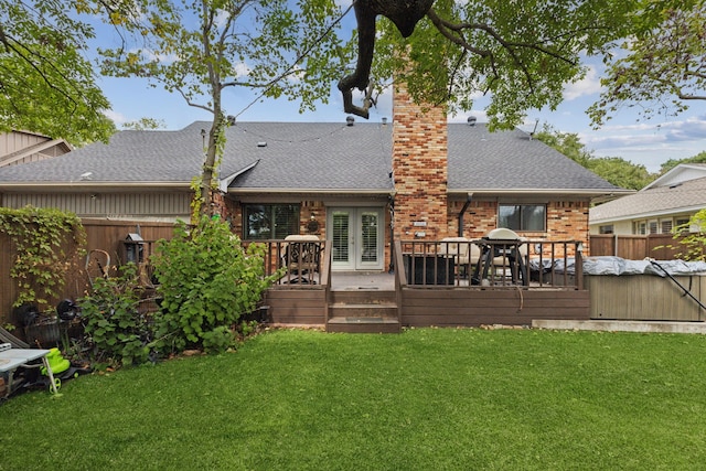 rear view of house featuring a lawn and a deck