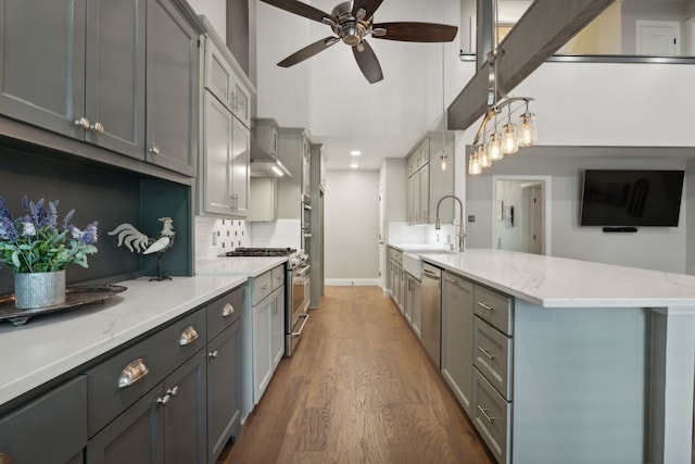 kitchen with appliances with stainless steel finishes, dark hardwood / wood-style flooring, gray cabinetry, ceiling fan, and sink