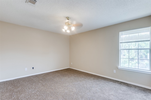 unfurnished room featuring a textured ceiling and carpet