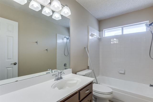 full bathroom featuring vanity, tiled shower / bath combo, toilet, and a textured ceiling