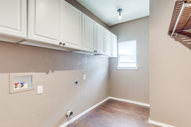 clothes washing area featuring hookup for an electric dryer, a textured ceiling, cabinets, hookup for a washing machine, and hardwood / wood-style floors