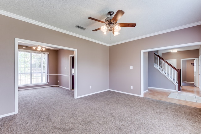 carpeted spare room with ceiling fan, crown molding, and a textured ceiling