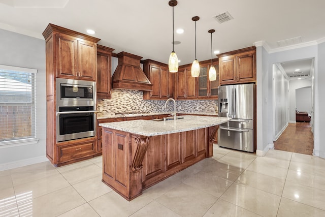 kitchen featuring sink, custom exhaust hood, stainless steel appliances, a center island with sink, and light stone countertops