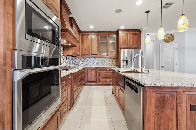 kitchen featuring crown molding, a center island with sink, appliances with stainless steel finishes, light tile patterned floors, and decorative light fixtures