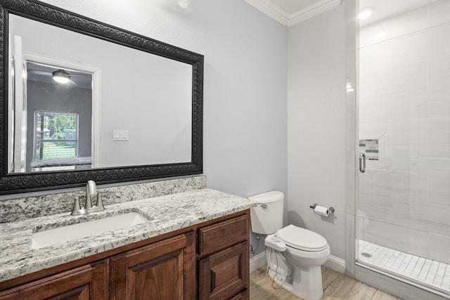 bathroom featuring vanity, hardwood / wood-style flooring, walk in shower, crown molding, and toilet