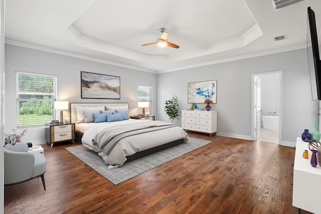 bedroom with a tray ceiling, ceiling fan, multiple windows, and dark hardwood / wood-style flooring