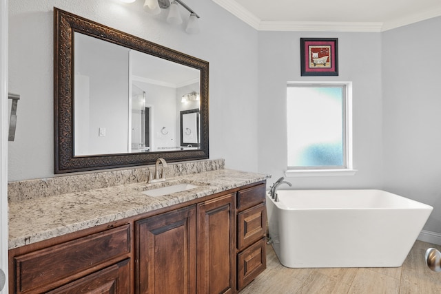 bathroom featuring a tub to relax in, crown molding, and vanity