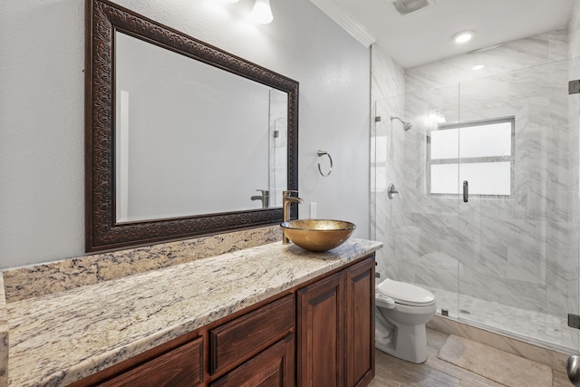 bathroom with vanity, hardwood / wood-style floors, ornamental molding, toilet, and a shower with door