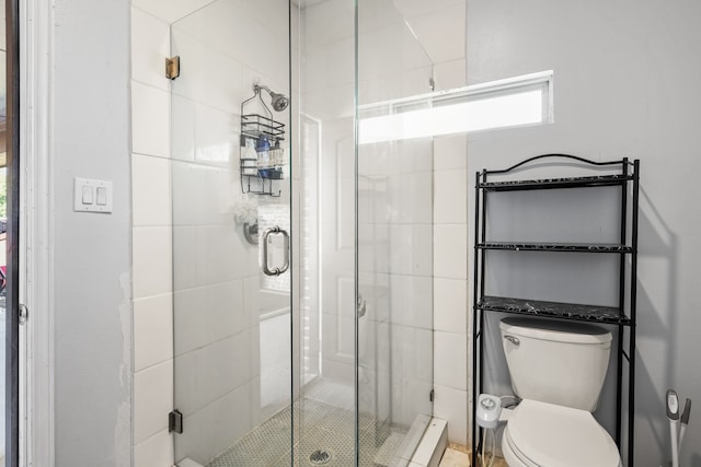 bathroom featuring toilet and an enclosed shower