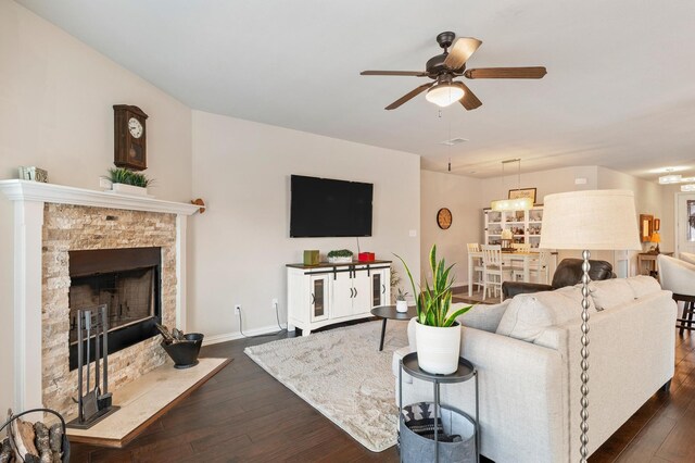 living room featuring ceiling fan, hardwood / wood-style flooring, and a fireplace