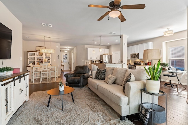 living room featuring wood-type flooring and ceiling fan